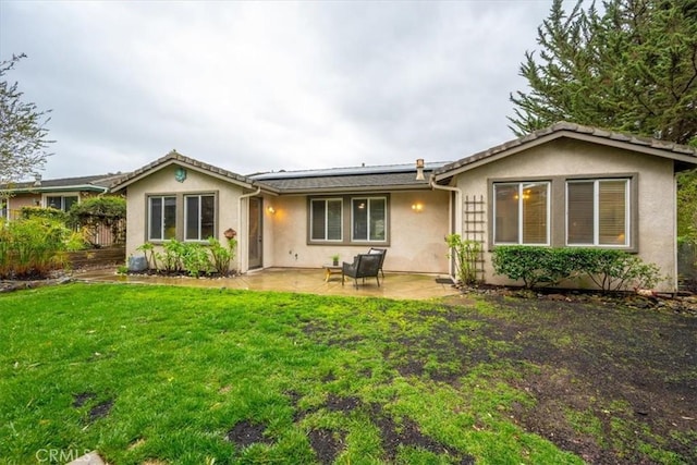 back of property featuring a patio and a lawn