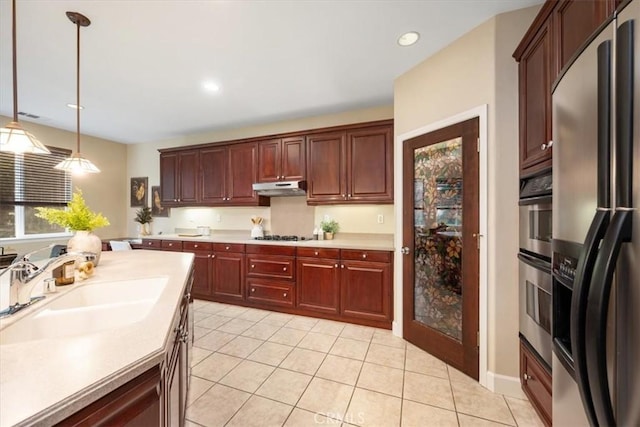 kitchen with stainless steel appliances, sink, hanging light fixtures, and light tile patterned floors