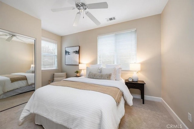 carpeted bedroom with ceiling fan and a closet