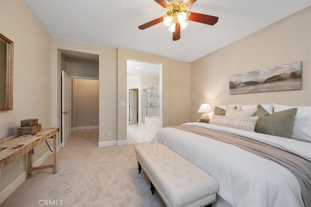 bedroom featuring light colored carpet, ceiling fan, and ensuite bathroom