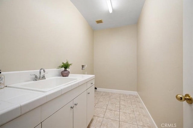 laundry area with sink, cabinets, and light tile patterned flooring