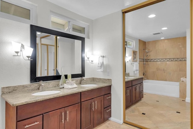 bathroom featuring tiled shower / bath and vanity