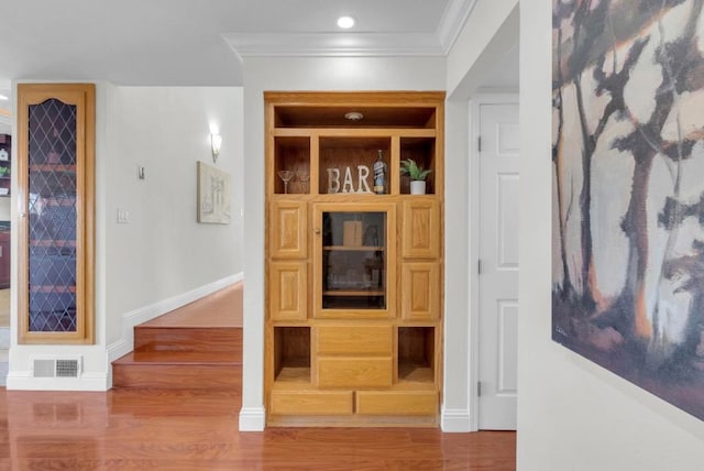 hall featuring ornamental molding, hardwood / wood-style floors, and built in features