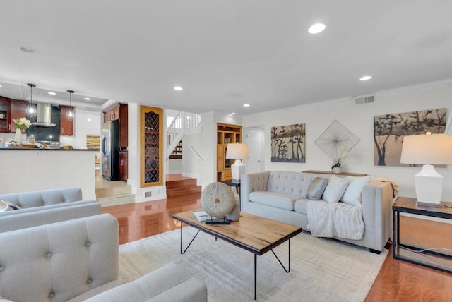 living room with ornamental molding and light hardwood / wood-style floors