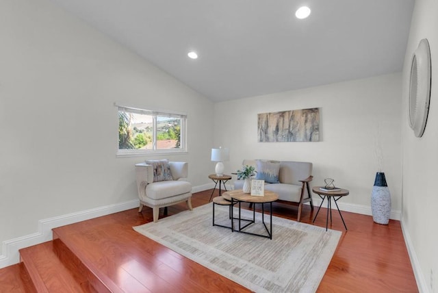 living room with hardwood / wood-style flooring and vaulted ceiling