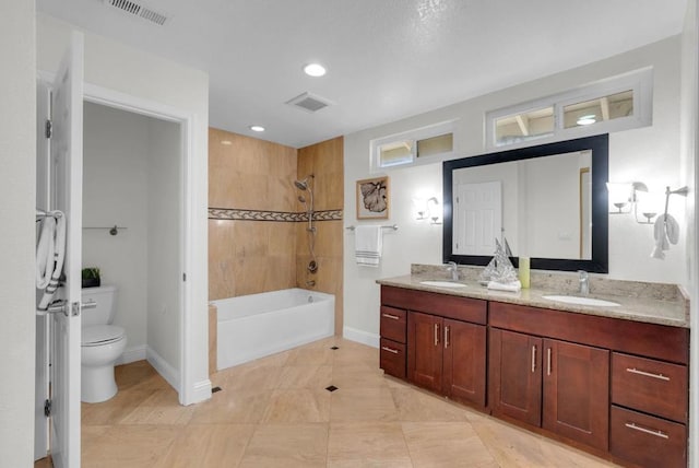 full bathroom featuring vanity, toilet, and tiled shower / bath combo