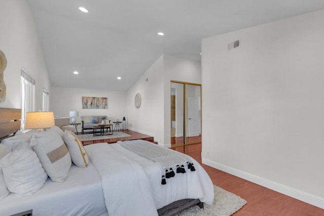 bedroom with wood-type flooring and vaulted ceiling