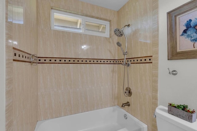 bathroom featuring tiled shower / bath combo and toilet