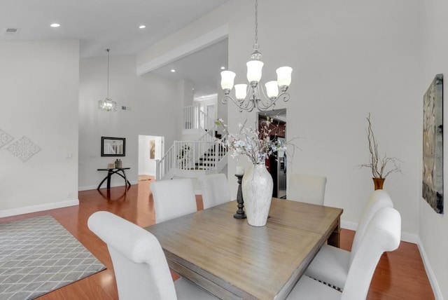 dining space featuring an inviting chandelier, wood-type flooring, beam ceiling, and high vaulted ceiling