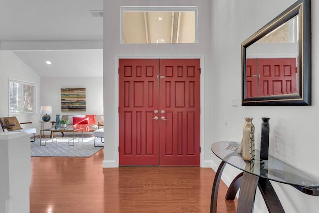 foyer entrance featuring lofted ceiling and hardwood / wood-style flooring