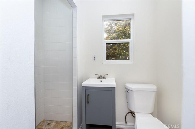 bathroom with vanity, a shower, and toilet