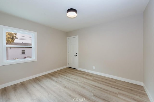 empty room featuring light wood-style flooring and baseboards