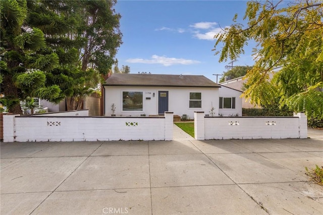 view of front of house featuring a fenced front yard and stucco siding