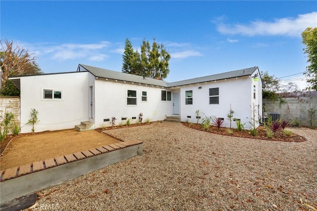 rear view of house featuring entry steps, crawl space, central AC, and stucco siding