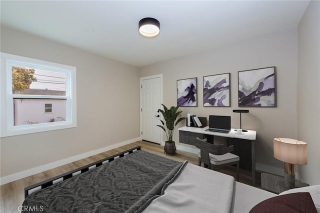 bedroom with baseboards and wood finished floors