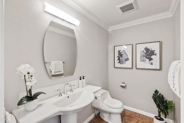 bathroom featuring crown molding, toilet, and sink