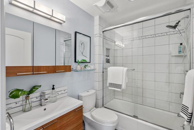 full bathroom with enclosed tub / shower combo, vanity, and toilet