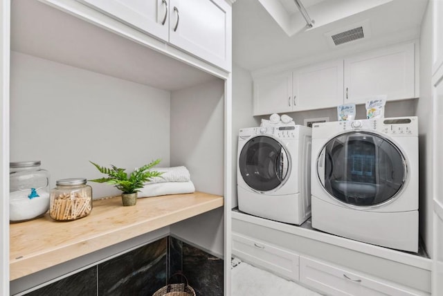 washroom featuring cabinets and separate washer and dryer