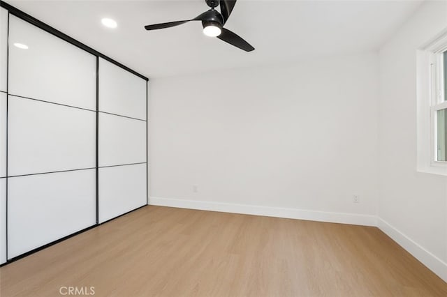 unfurnished bedroom with ceiling fan and light wood-type flooring