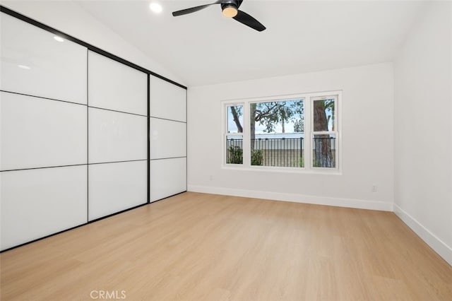 unfurnished bedroom featuring vaulted ceiling, light hardwood / wood-style floors, and ceiling fan