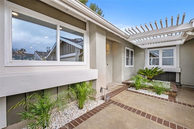 entrance to property featuring a pergola and a patio