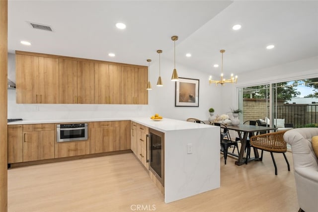 kitchen featuring pendant lighting, wine cooler, light hardwood / wood-style floors, kitchen peninsula, and oven