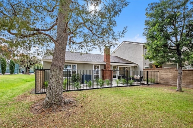 rear view of property with a lawn