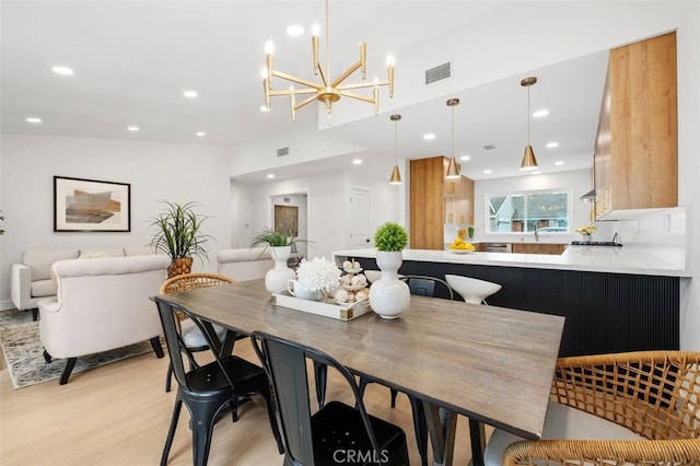 dining room with a notable chandelier and light hardwood / wood-style floors