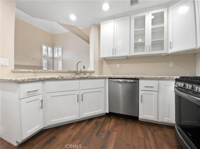 kitchen featuring sink, white cabinetry, stainless steel appliances, light stone counters, and dark hardwood / wood-style flooring