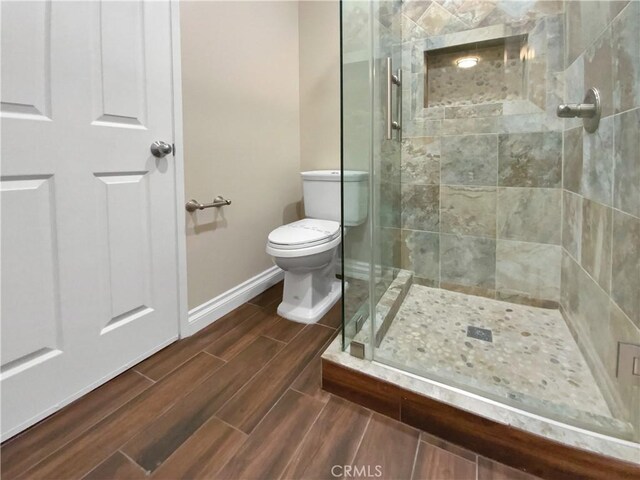 bathroom featuring walk in shower and toilet