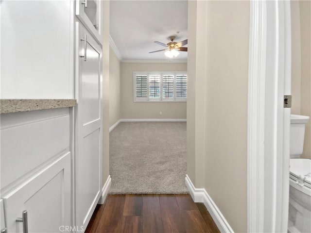 hall with dark wood-type flooring and ornamental molding