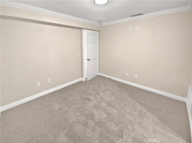 unfurnished room with crown molding and carpet floors