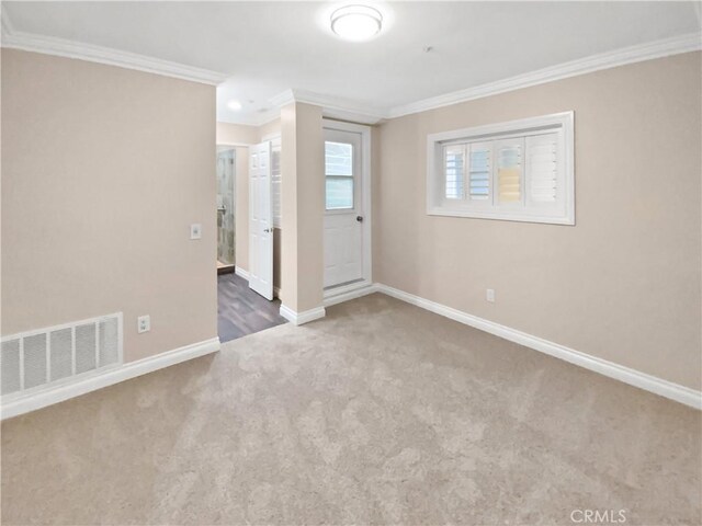 unfurnished room with crown molding and carpet