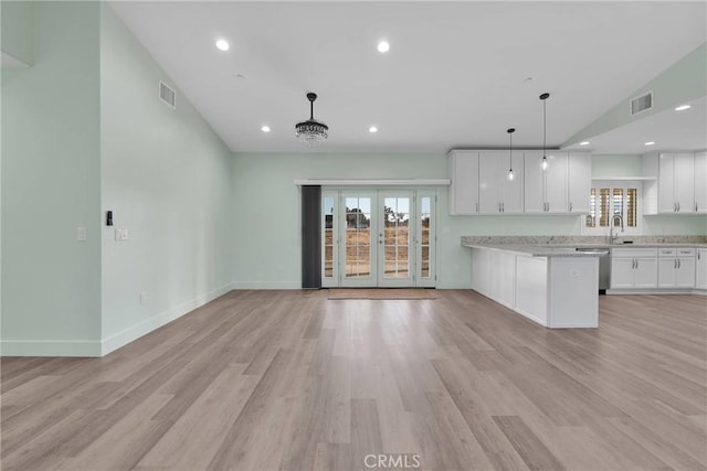 kitchen featuring french doors, white cabinets, light hardwood / wood-style floors, and decorative light fixtures