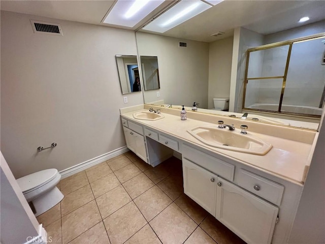 bathroom featuring tile patterned floors, toilet, a shower with door, and vanity