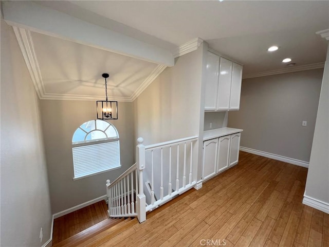 interior space featuring hardwood / wood-style floors, a notable chandelier, and ornamental molding