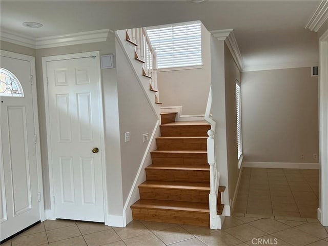 tiled entrance foyer featuring crown molding