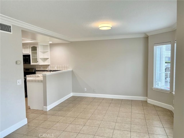 kitchen featuring white cabinetry, light tile patterned floors, crown molding, and decorative backsplash