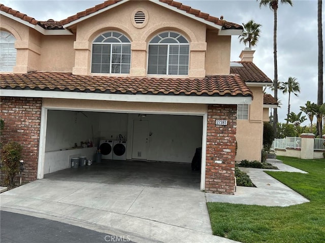 view of property exterior with a garage and separate washer and dryer