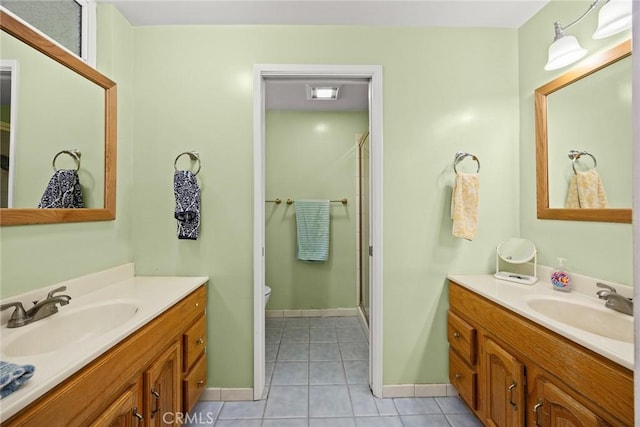 bathroom featuring tile patterned flooring, vanity, a shower with shower door, and toilet