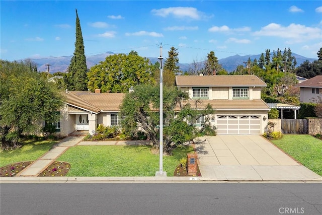 view of front of house featuring a mountain view, a garage, and a front lawn