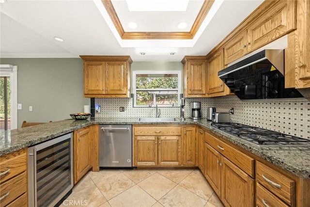 kitchen featuring appliances with stainless steel finishes, sink, beverage cooler, dark stone counters, and plenty of natural light