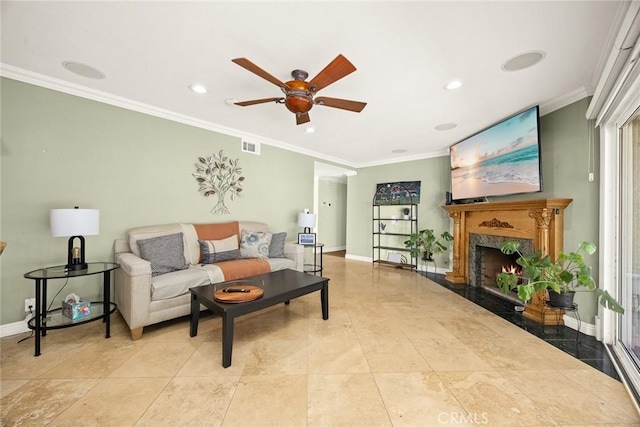 living room with crown molding, a premium fireplace, ceiling fan, and light tile patterned flooring