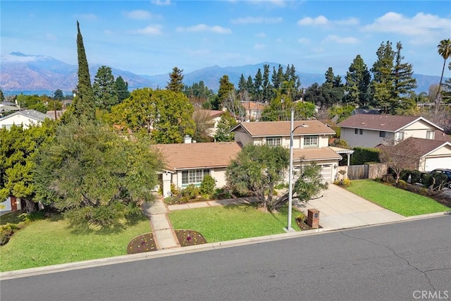 view of front of home featuring a garage, a mountain view, and a front lawn