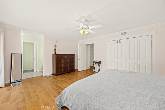 bedroom featuring crown molding, hardwood / wood-style flooring, a closet, and ceiling fan