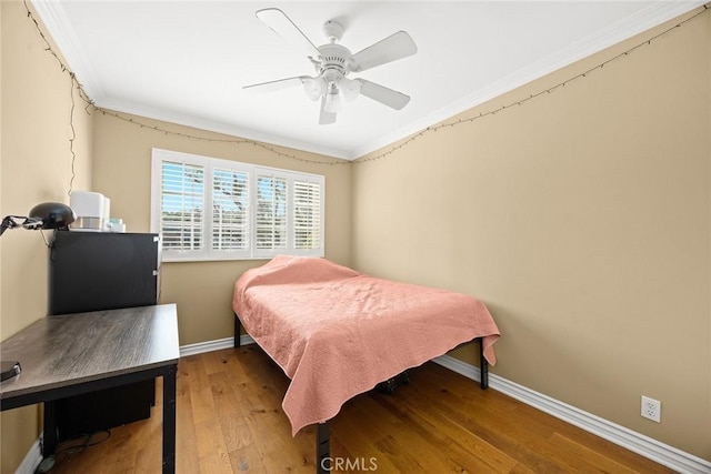 bedroom featuring hardwood / wood-style flooring, ceiling fan, and ornamental molding