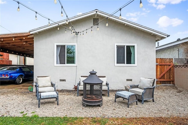 back of property with an outdoor fire pit