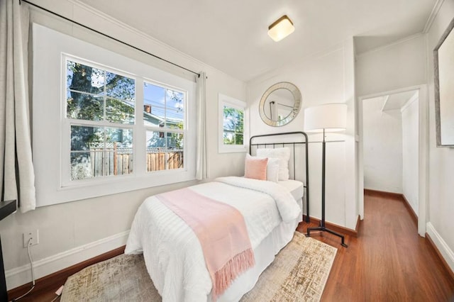 bedroom with crown molding and dark hardwood / wood-style flooring