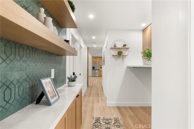 interior space featuring stainless steel fridge and light hardwood / wood-style floors