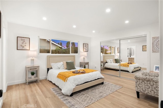 bedroom featuring multiple windows, a closet, and light wood-type flooring